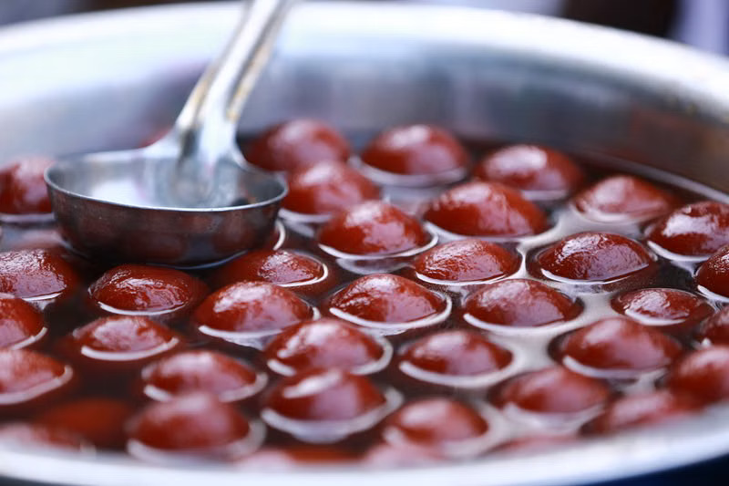 Gulab jamun in a steel pot